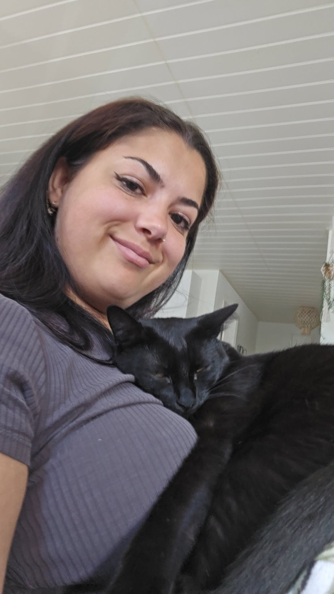Marielle Giroud avec son chat noir, en gros plan.